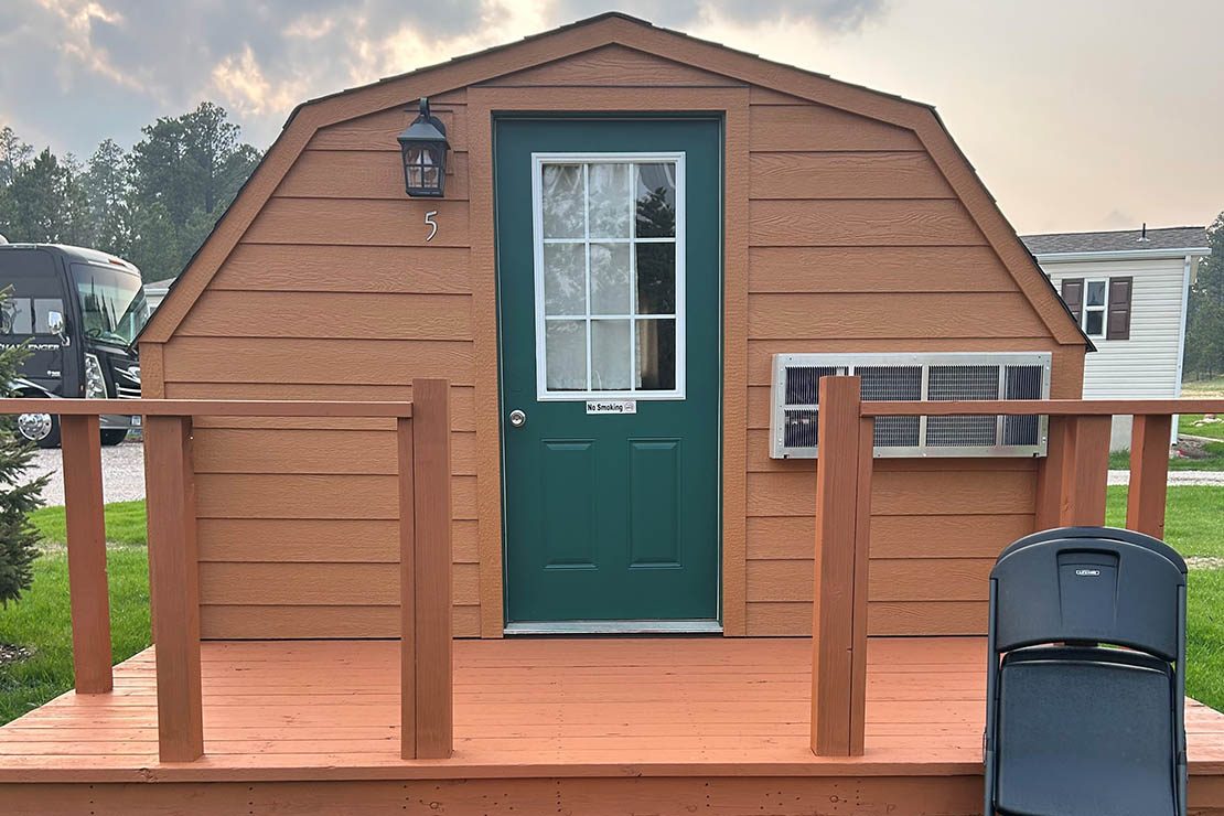 Camping cabin with a front deck at Custer Crossing Family Campground near Deadwood, SD